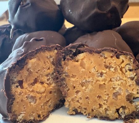 dark chocolate peanut butter crispy balls stacked with one cut open