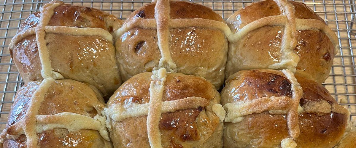 Six hot cross buns on a cooling rack