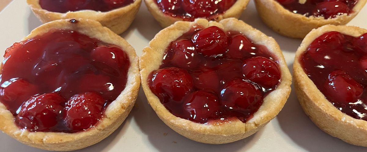 Close-up of two rows of three mini cherry pies no whipped topping