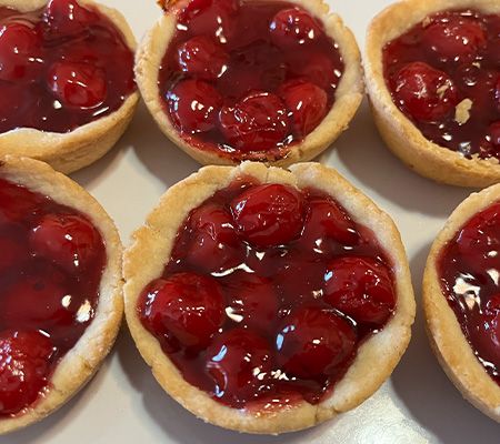 Close-up of two rows of three mini cherry pies no whipped topping