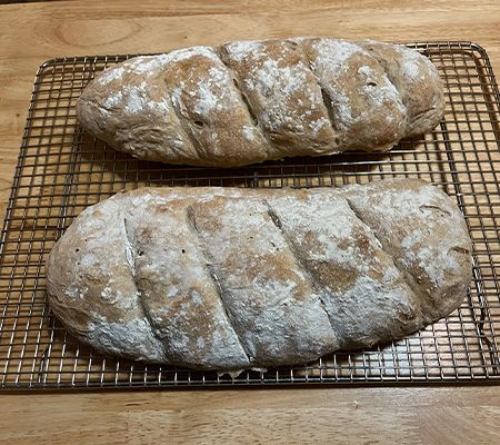 Two loaves of sourdough bread on a cooling rack