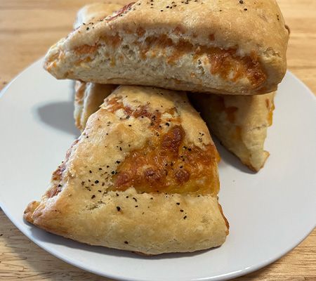 Stack of triangle shaped cheese biscuits on a white plate