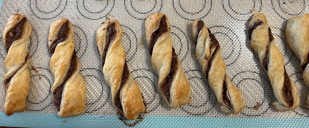 row of 7 chocolate twists on a silpat baking sheet