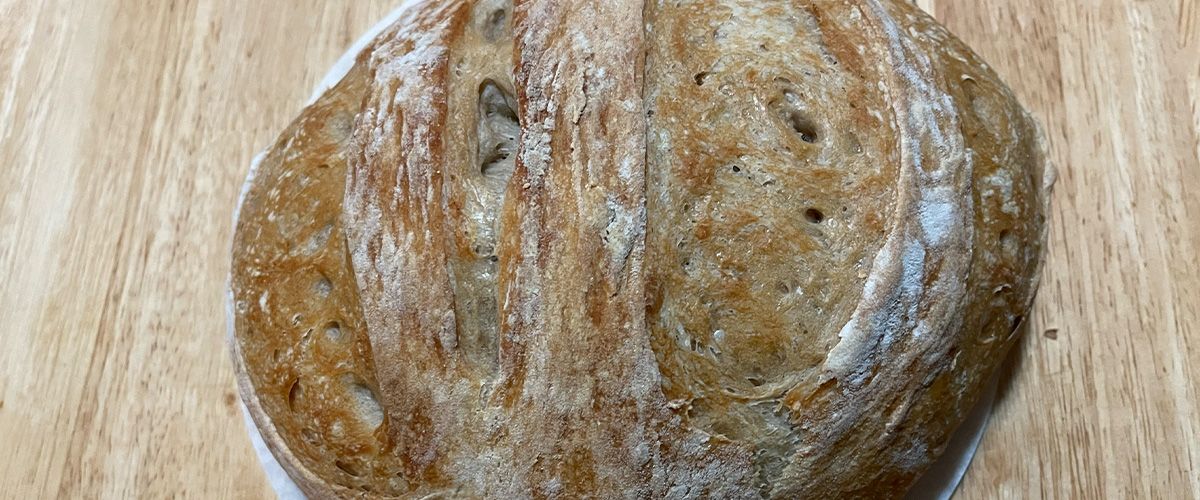 Sourdough boule on parchment on a wooden table