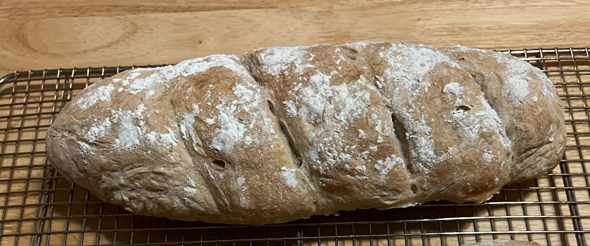 A loaf of sourdough bread on a cooling rack